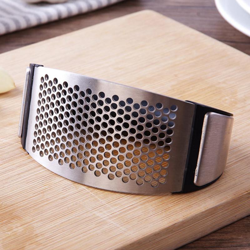 A sleek stainless steel garlic press with an ergonomic rocking design, ideal for crushing garlic effortlessly.