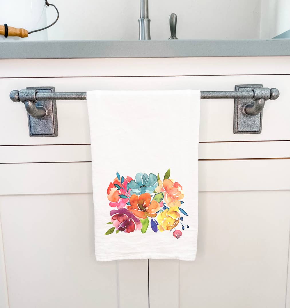 A vibrant cotton tea towel featuring a summer flower bouquet design, hemmed edges, and a soft texture, perfect for kitchen use.