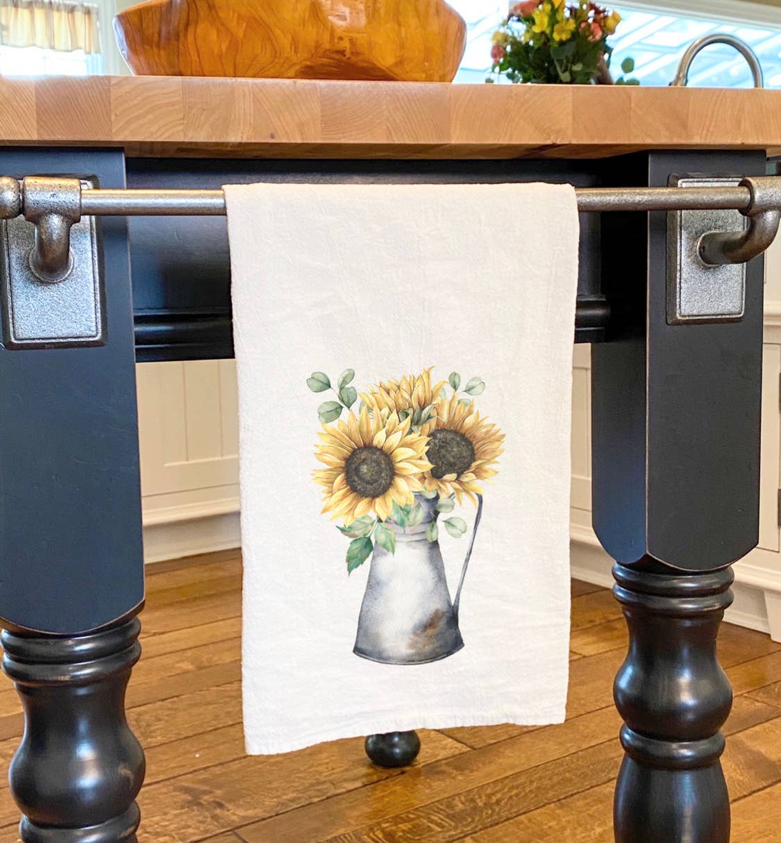 A vibrant cotton tea towel featuring sunflowers in a jug design, showcasing its absorbent fabric and hemmed edges.