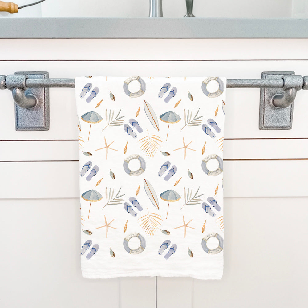 A vibrant cotton tea towel featuring a surf and shells pattern, showcasing ocean-inspired designs in bright colors.