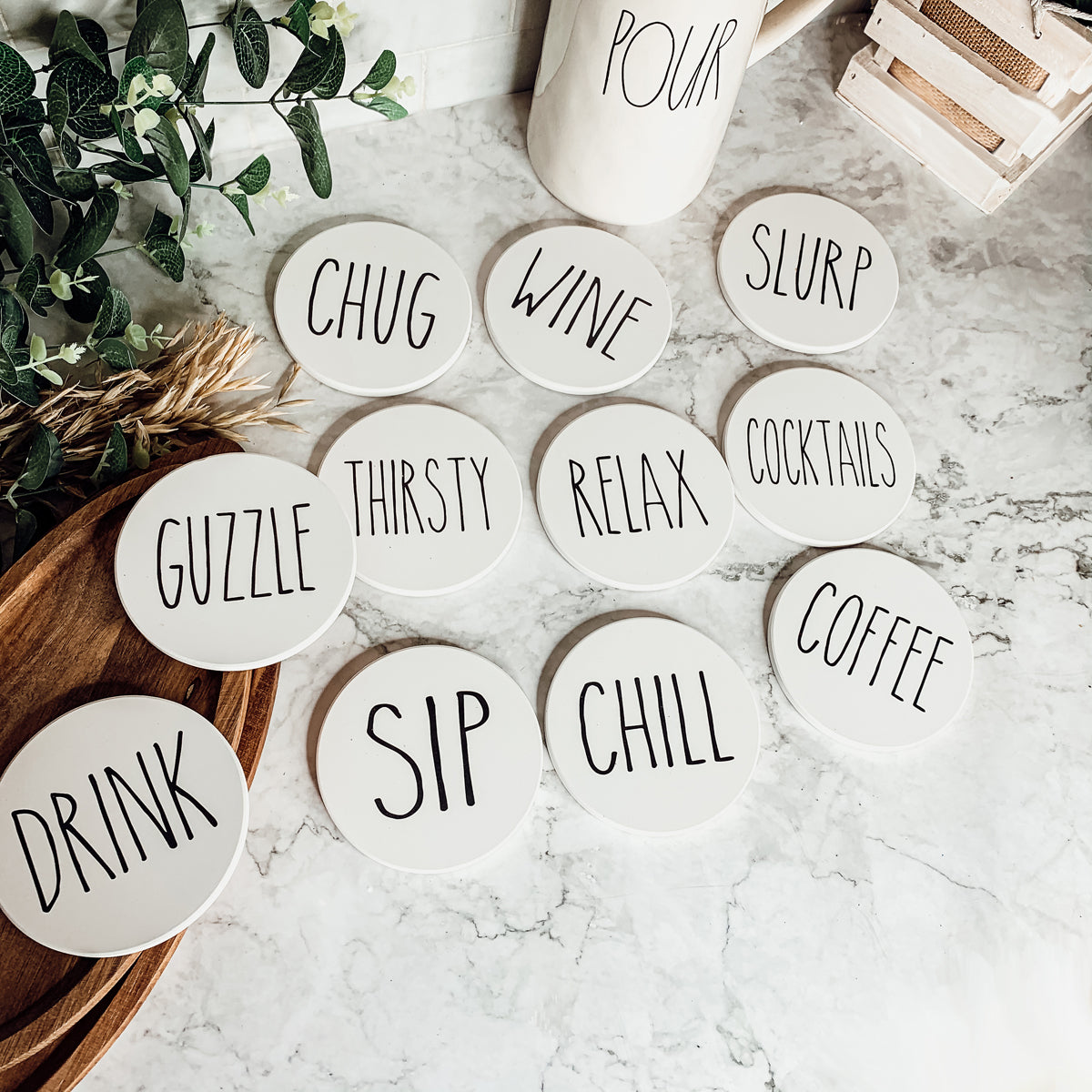 A stylish set of ceramic coasters with cork backing, featuring various fun designs for kitchen decor.