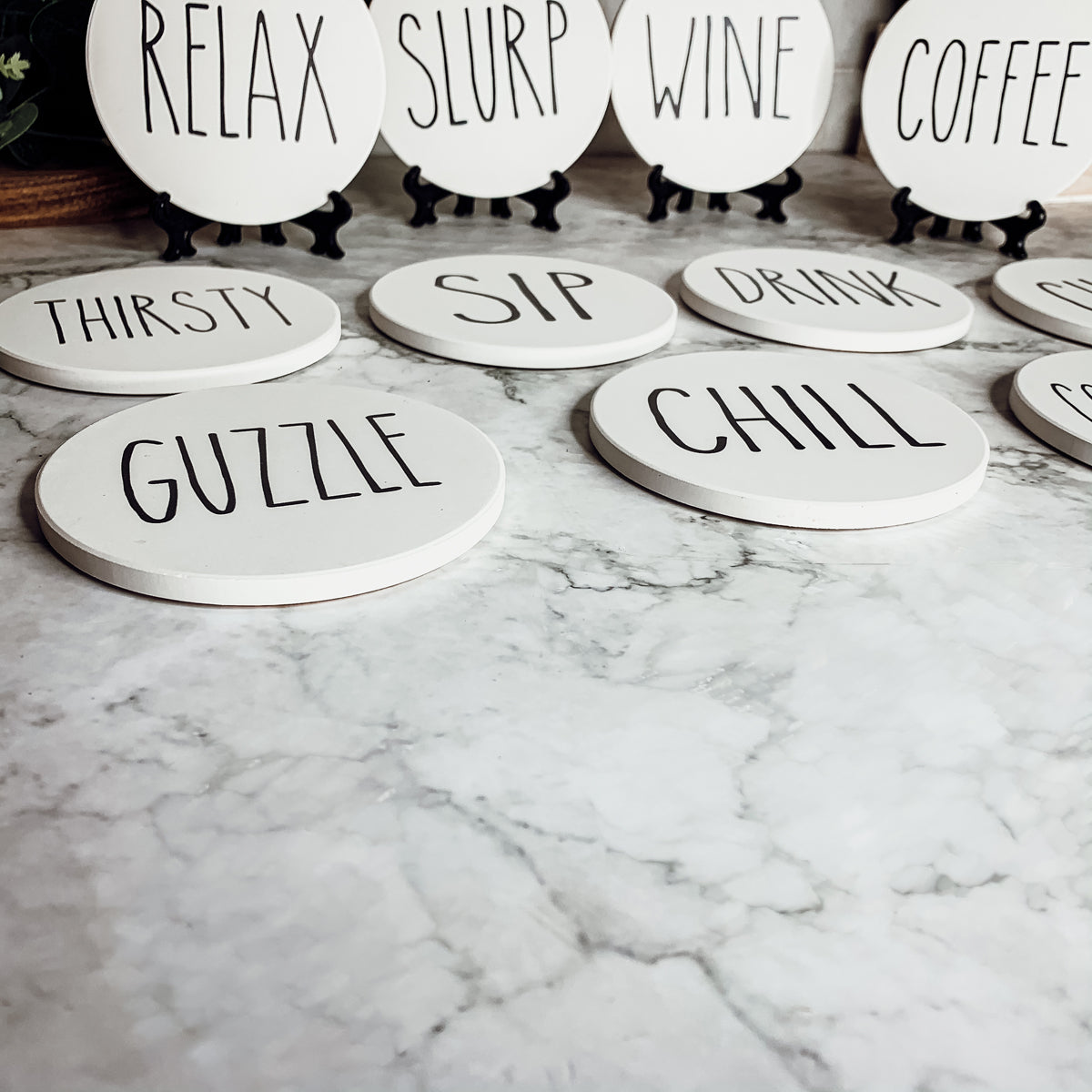 A stylish set of ceramic coasters with cork backing, featuring various fun designs for kitchen decor.