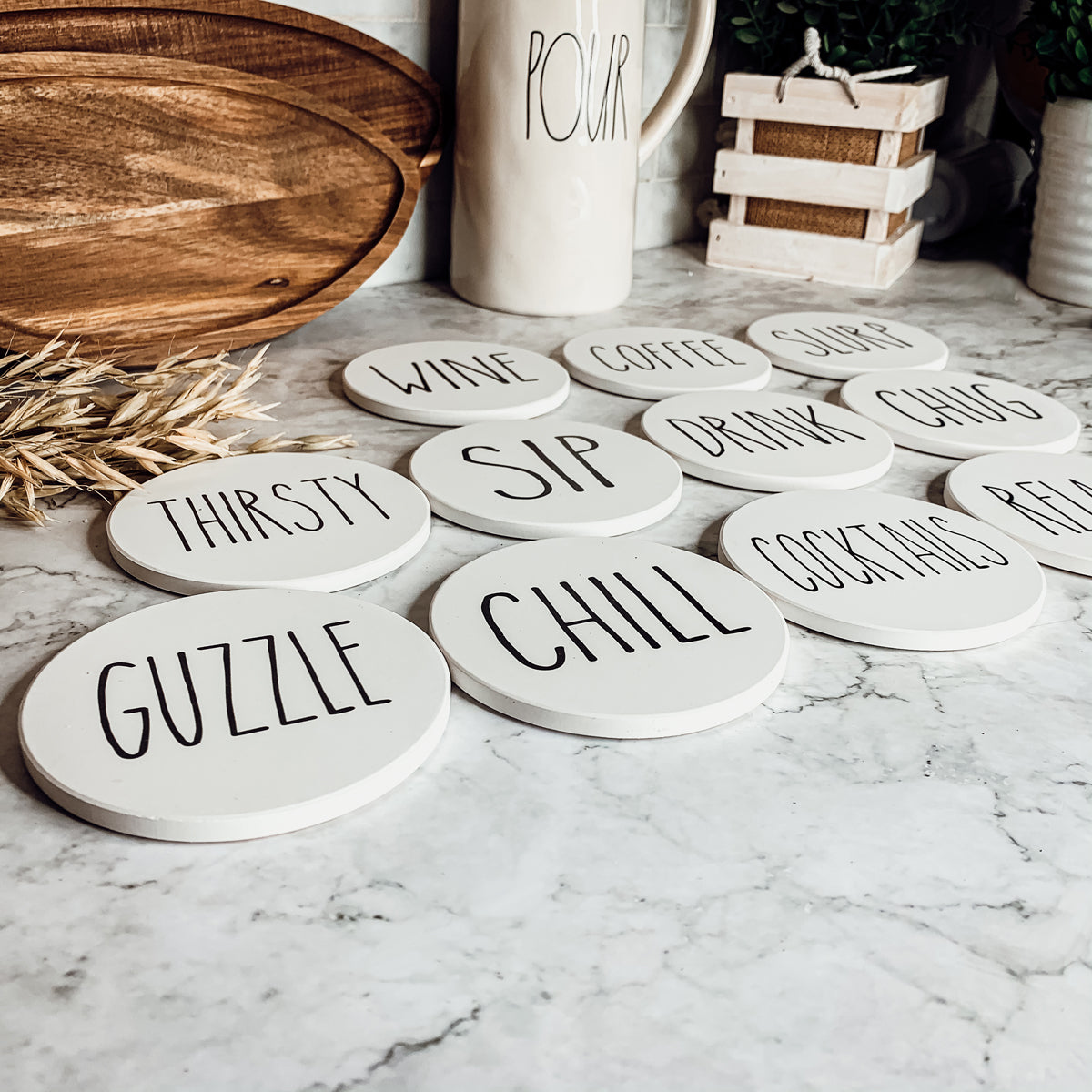 A stylish set of ceramic coasters with cork backing, featuring various fun designs for kitchen decor.