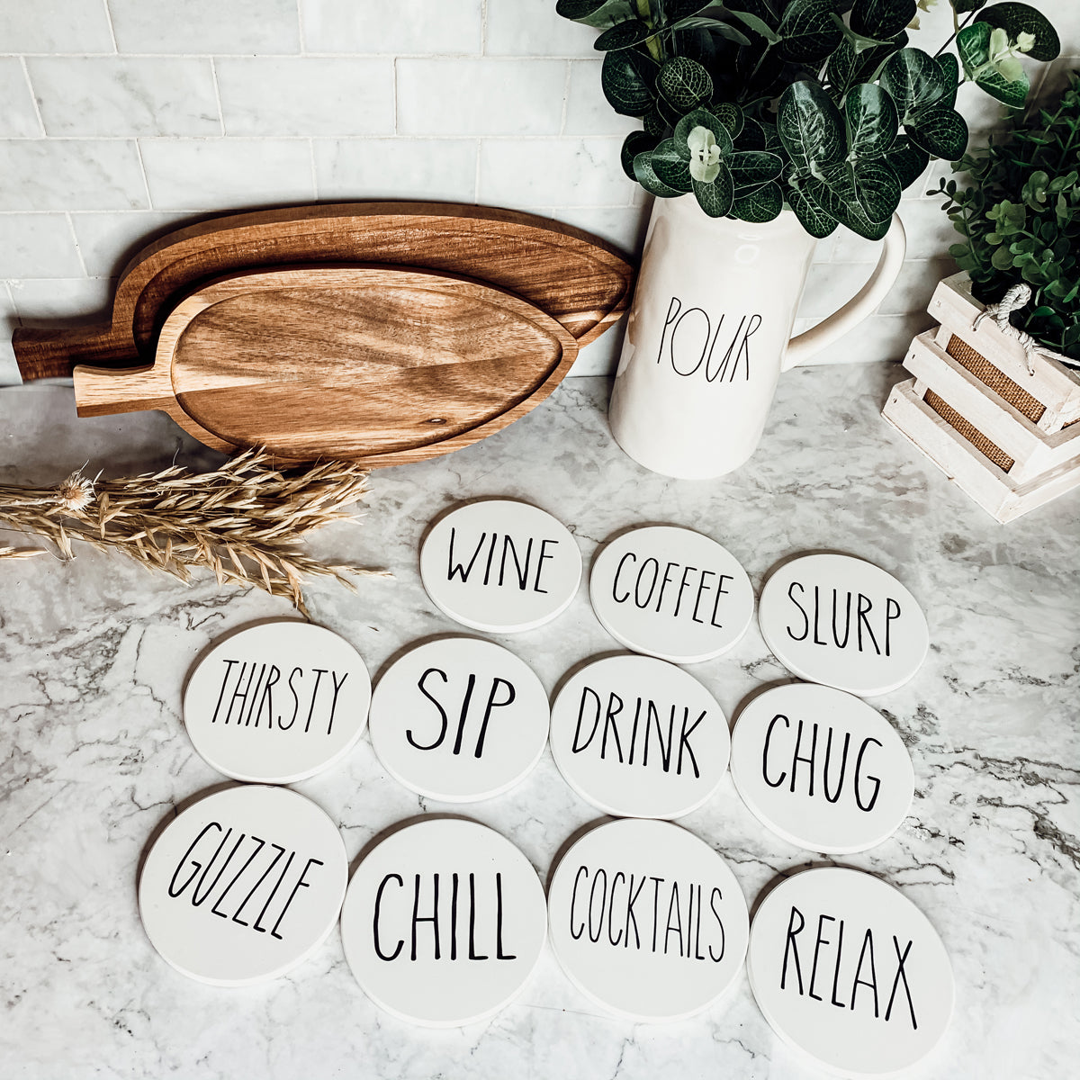 A stylish set of ceramic coasters with cork backing, featuring various fun designs for kitchen decor.