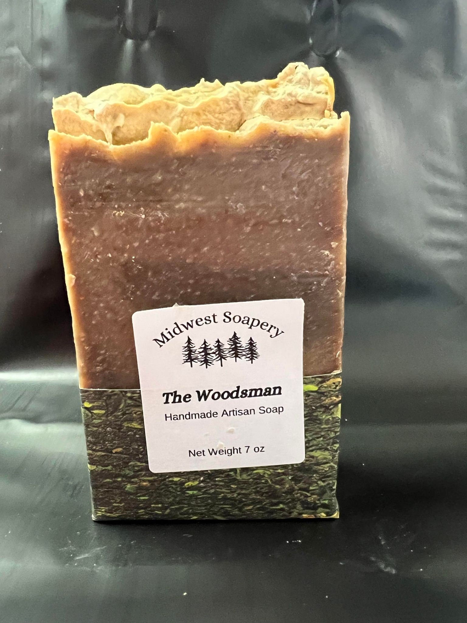 The Woodsman soap bar featuring a blend of smoky wood and sweet vanilla, presented in a large 7 oz size.