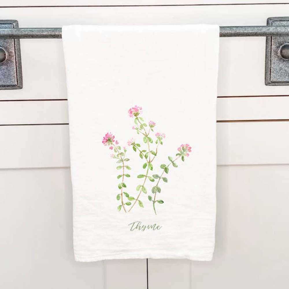 Thyme Cotton Tea Towel featuring a vibrant thyme design, made from 100% absorbent cotton, displayed on a kitchen countertop.