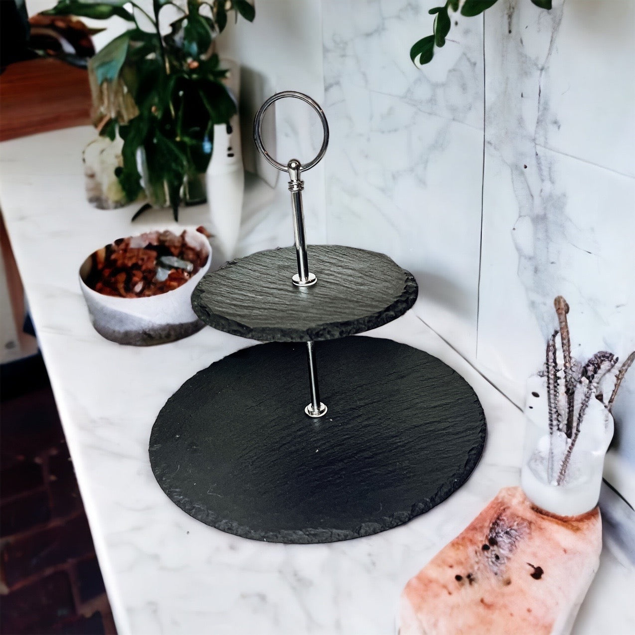 A stylish tiered slate stand showcasing appetizers and desserts, featuring natural edges and a modern design.