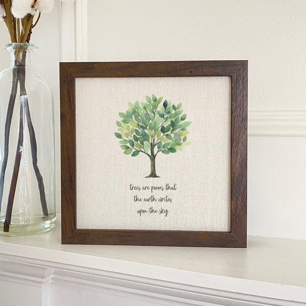 Framed sign reading 'Trees are Poems' with a stylized wood frame, available in walnut or white-washed finish.