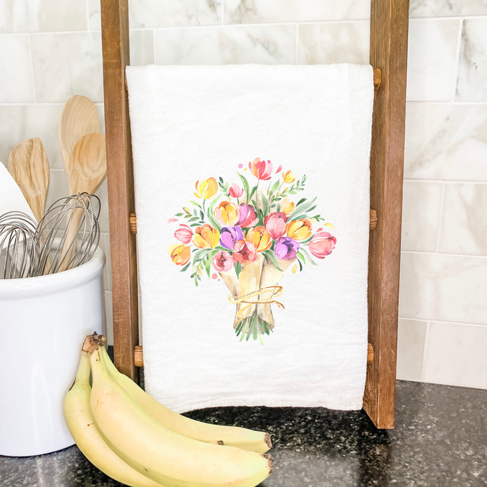 A vibrant cotton tea towel featuring a beautiful tulip bouquet design, perfect for kitchen use.