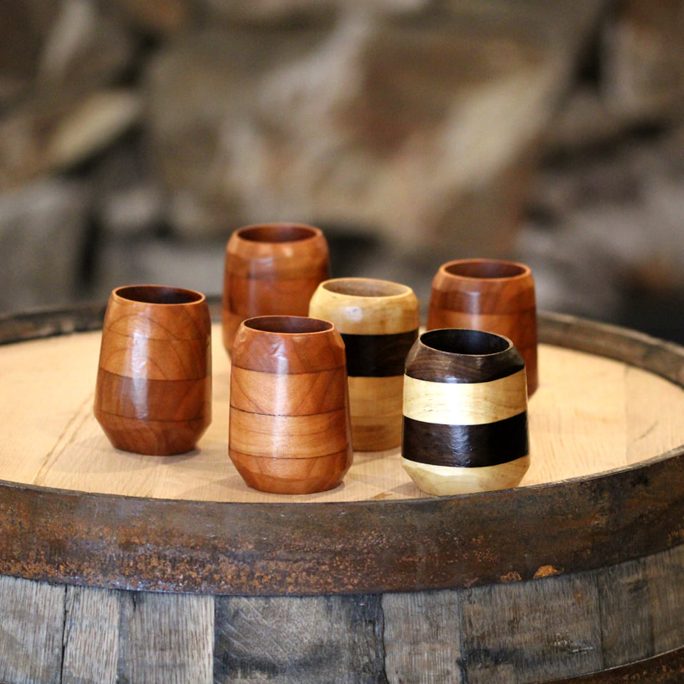 Artisan wooden tumbler made from walnut, cherry, and maple, showcasing unique wood grains and a food-safe finish.