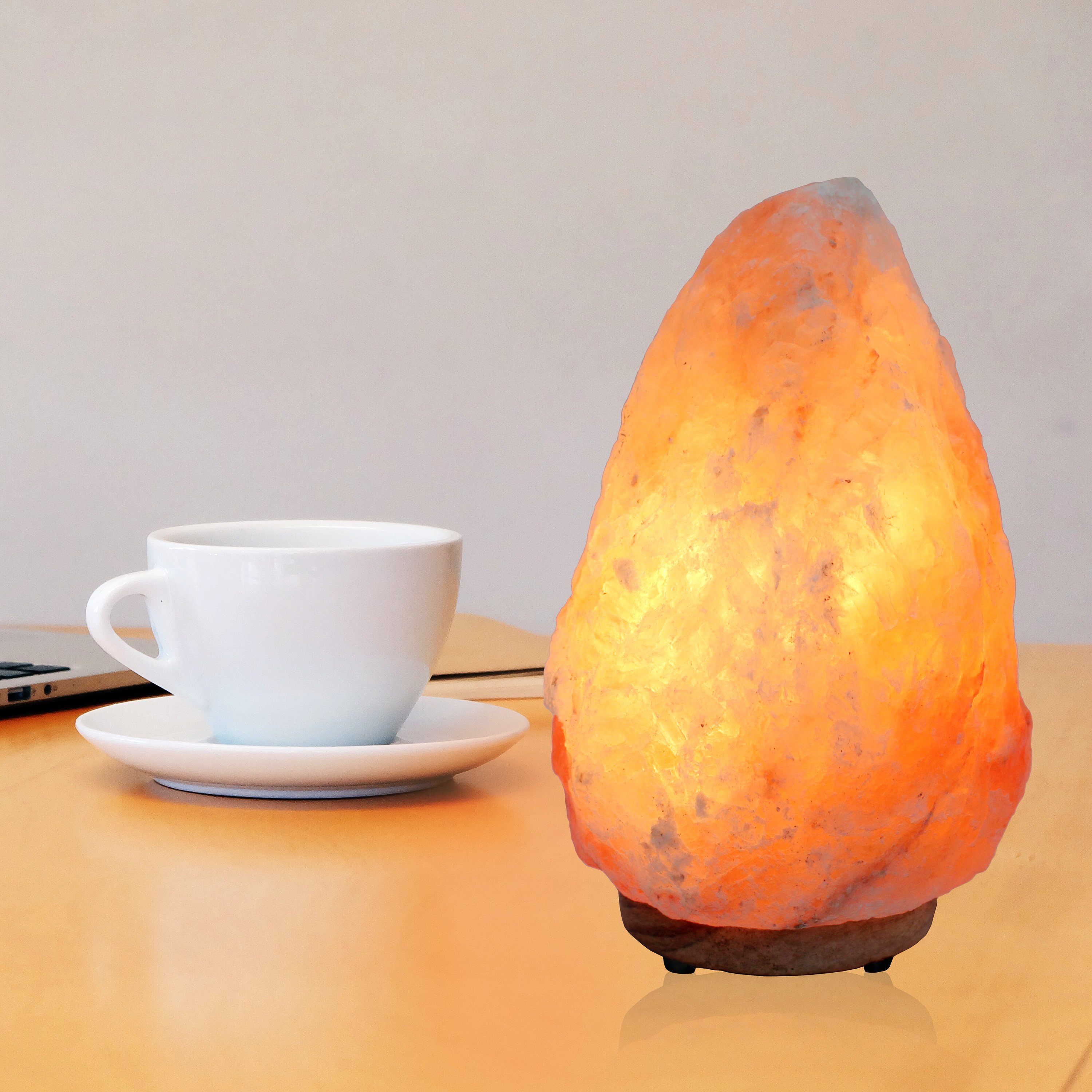 UMAID Himalayan Salt Lamp with a warm glow, set on a sturdy neem wooden base, showcasing its natural beauty and calming ambiance.