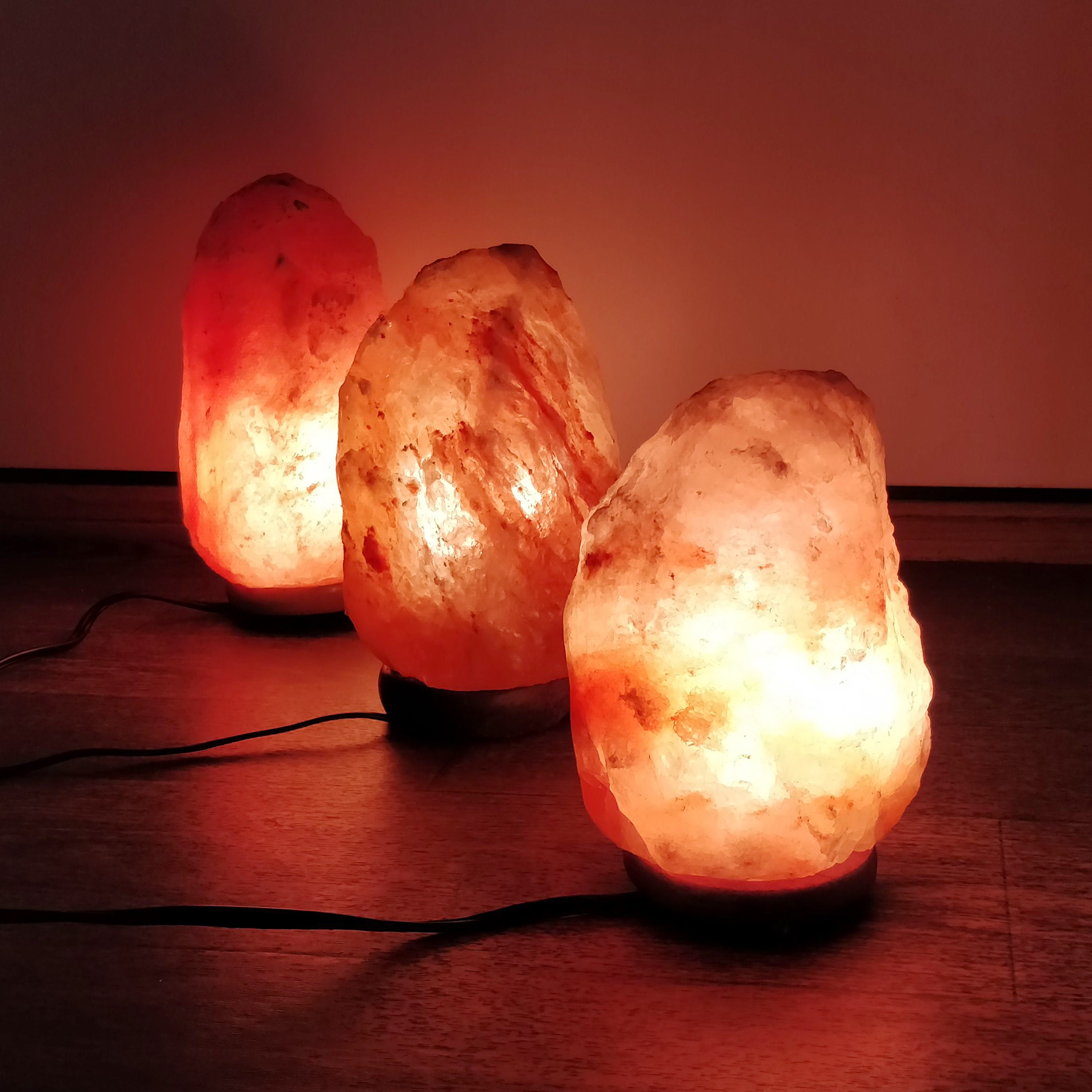 UMAID Himalayan Salt Lamp with a warm glow, set on a sturdy neem wooden base, showcasing its natural beauty and calming ambiance.