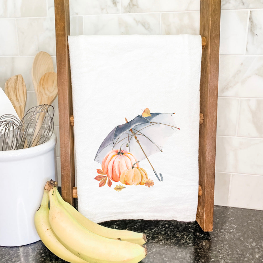 A vibrant cotton tea towel featuring a charming Umbrella Pumpkins design, perfect for kitchen use.