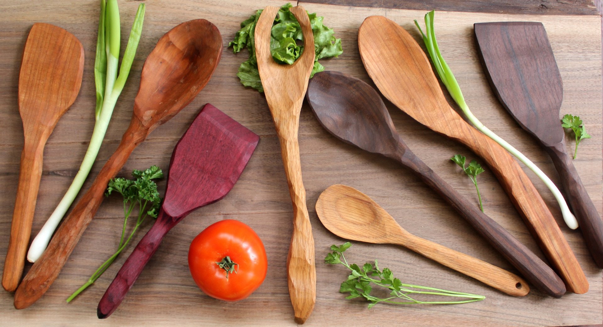 A beautifully arranged 8 piece collection of handcarved wooden spoons, including spatulas and serving utensils made from Oak, Cherry, Walnut, and Purple Heart.