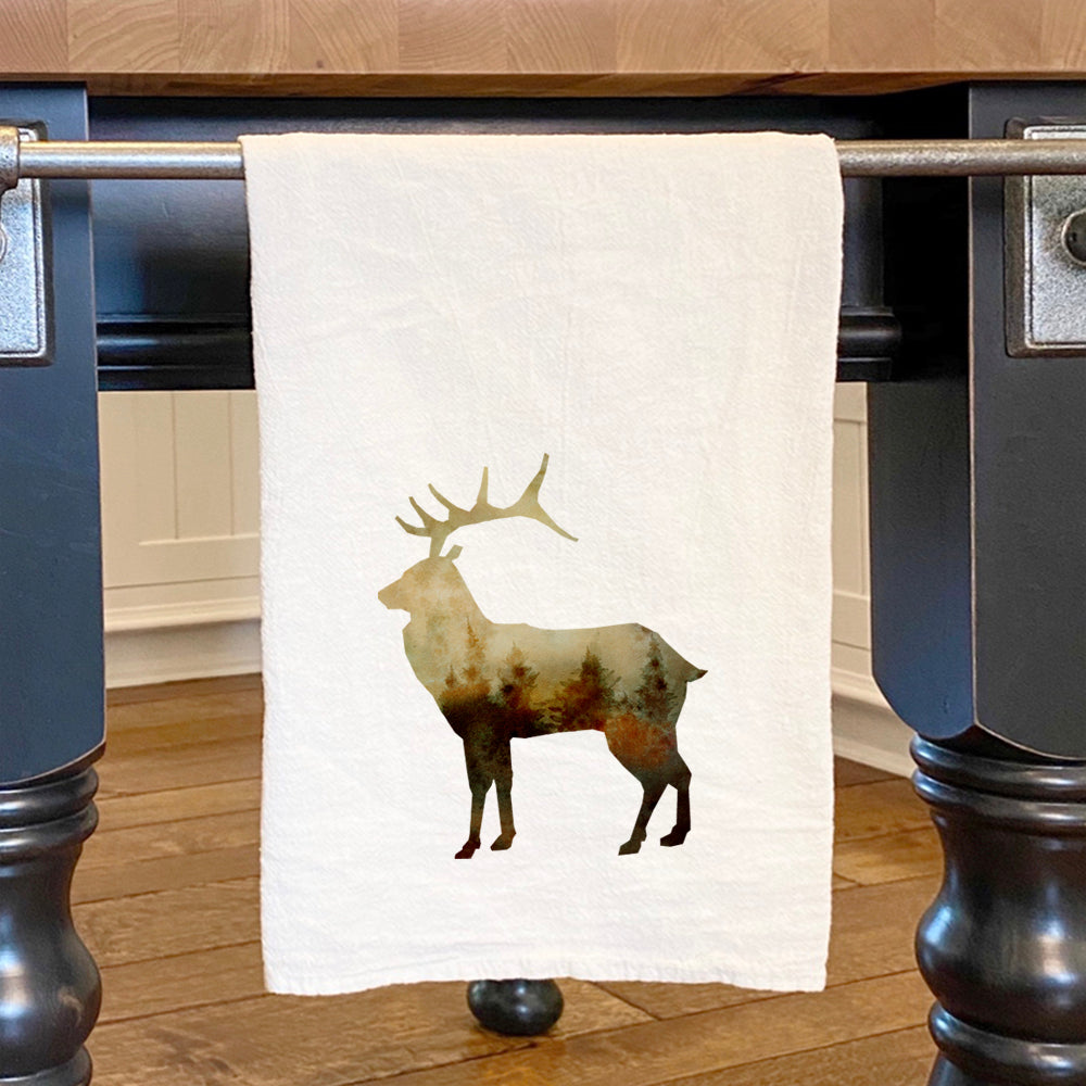 A vibrant watercolor elk design on a cotton tea towel, showcasing its absorbent texture and hemmed edges.