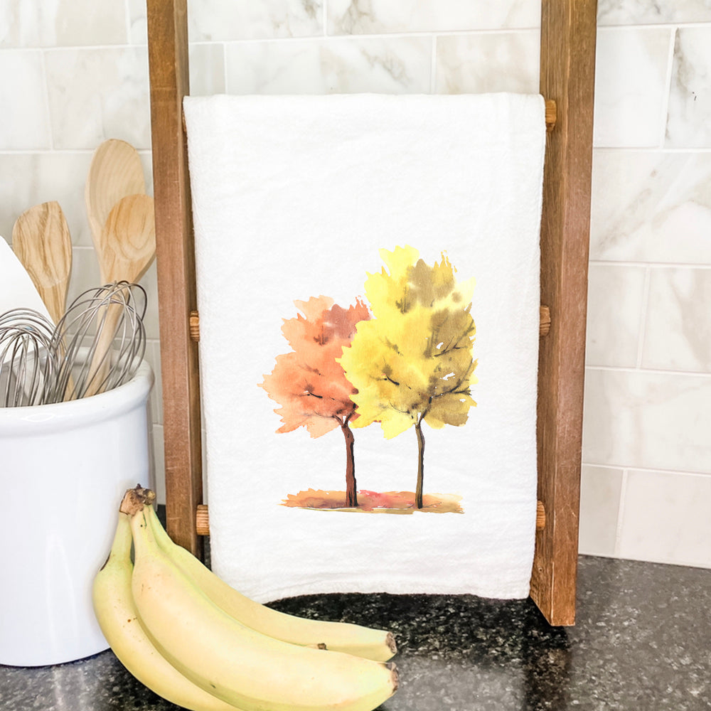 A pair of cotton tea towels featuring vibrant watercolor fall trees design, perfect for kitchen use and decor.