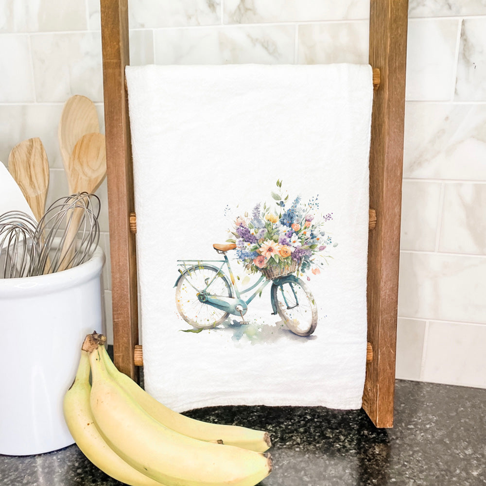 A vibrant cotton tea towel featuring a watercolor floral bike design, perfect for kitchen use.