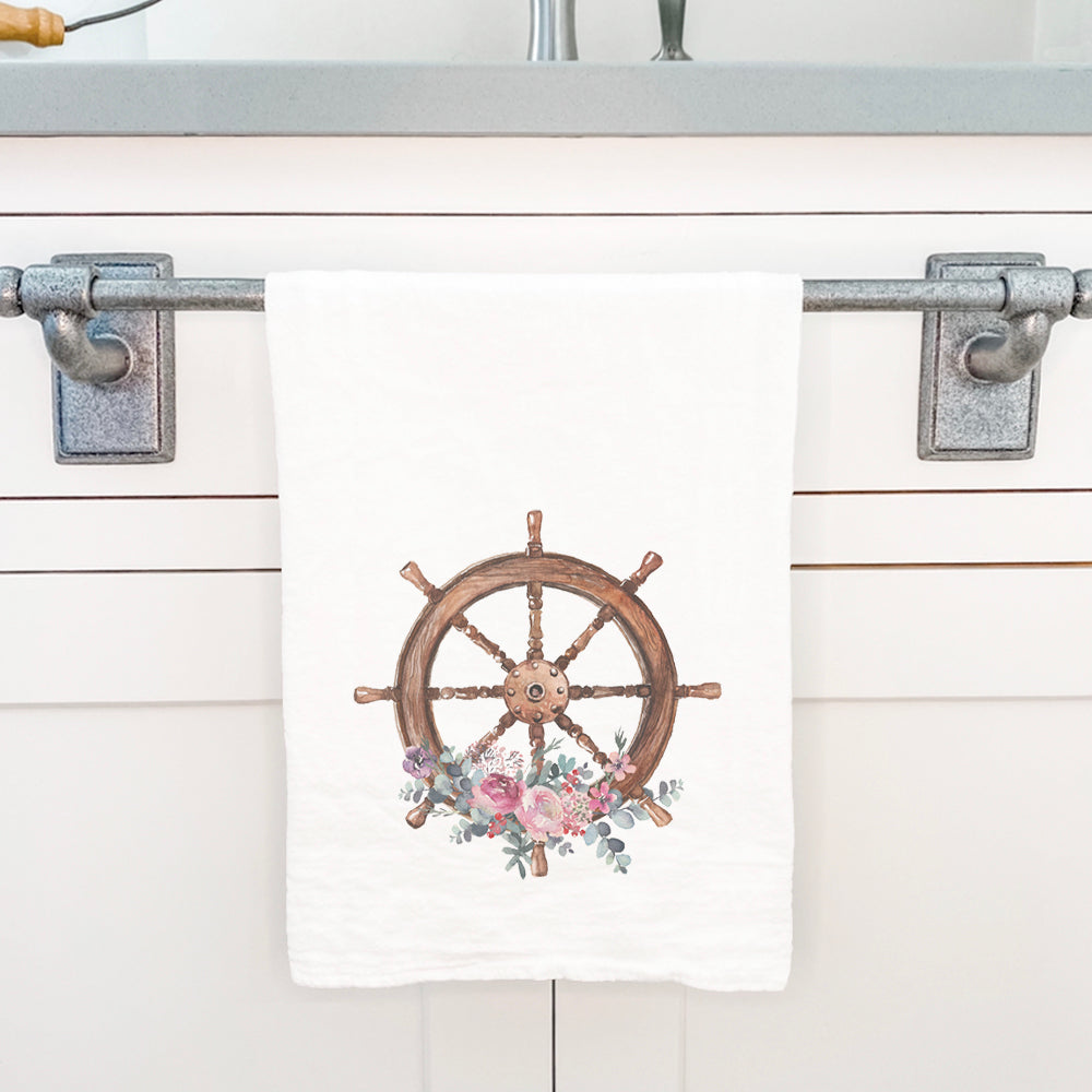 A vibrant watercolor floral ship wheel design on a cotton tea towel, showcasing its absorbent texture and hemmed edges.