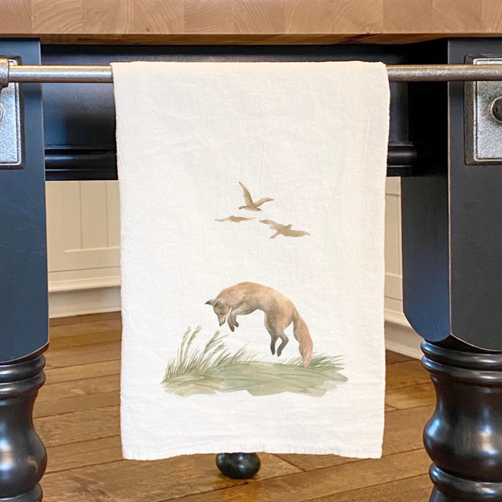 A beautifully designed cotton tea towel featuring a vibrant watercolor fox scene, perfect for kitchen use.