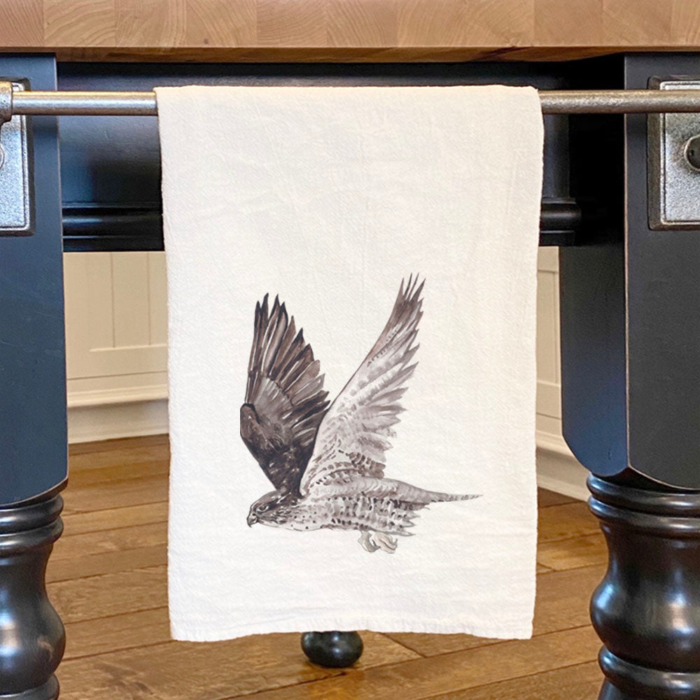 A vibrant watercolor design of a hawk on a cotton tea towel, showcasing its absorbent texture and hemmed edges.