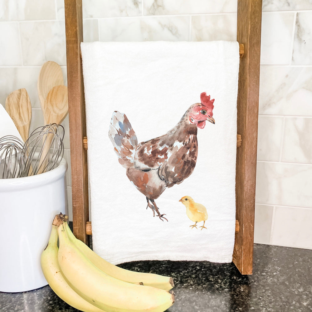 A vibrant cotton tea towel featuring a watercolor hen with her chick, showcasing a rustic and charming design.