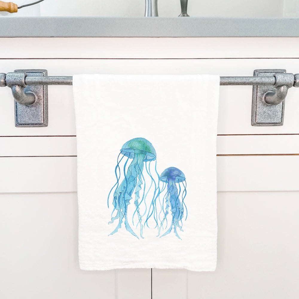 A vibrant watercolor jellyfish design on a cotton tea towel, showcasing its absorbent fabric and hemmed edges.