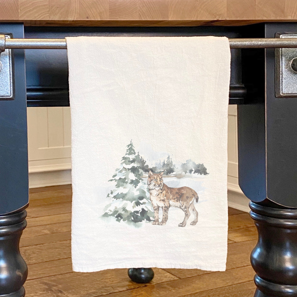 A vibrant cotton tea towel featuring a watercolor lynx scene, showcasing intricate details and colors, perfect for kitchen use.