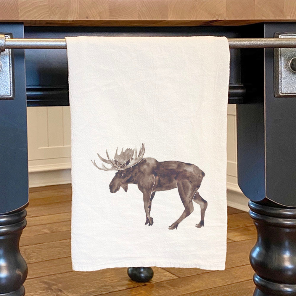 A vibrant watercolor moose design on a 100% cotton tea towel, showcasing its absorbent and durable flour sack style.