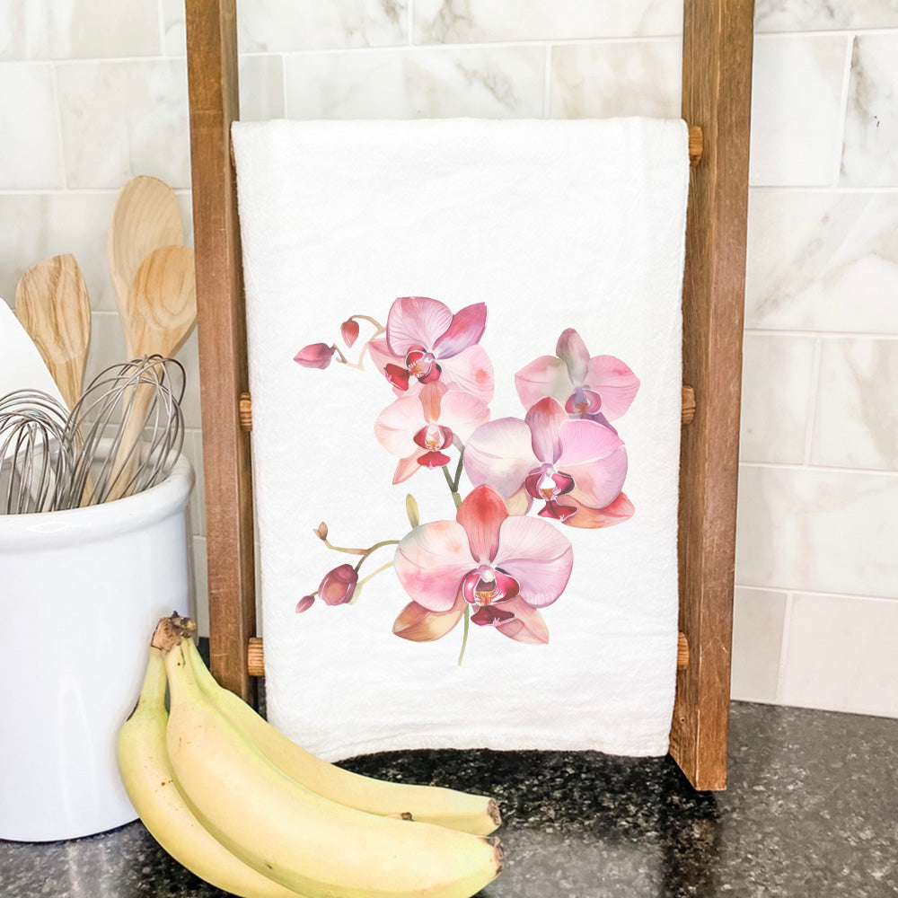 A vibrant cotton tea towel featuring watercolor orchid blooms, showcasing a beautiful floral design on a white background.