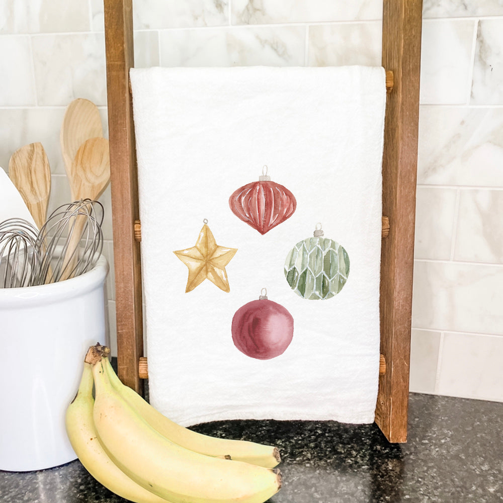 A vibrant cotton tea towel featuring watercolor ornaments, showcasing its absorbent texture and hemmed edges.