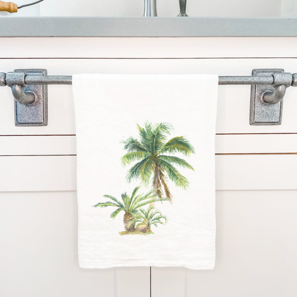 A vibrant cotton tea towel featuring a watercolor palm design, perfect for kitchen use.