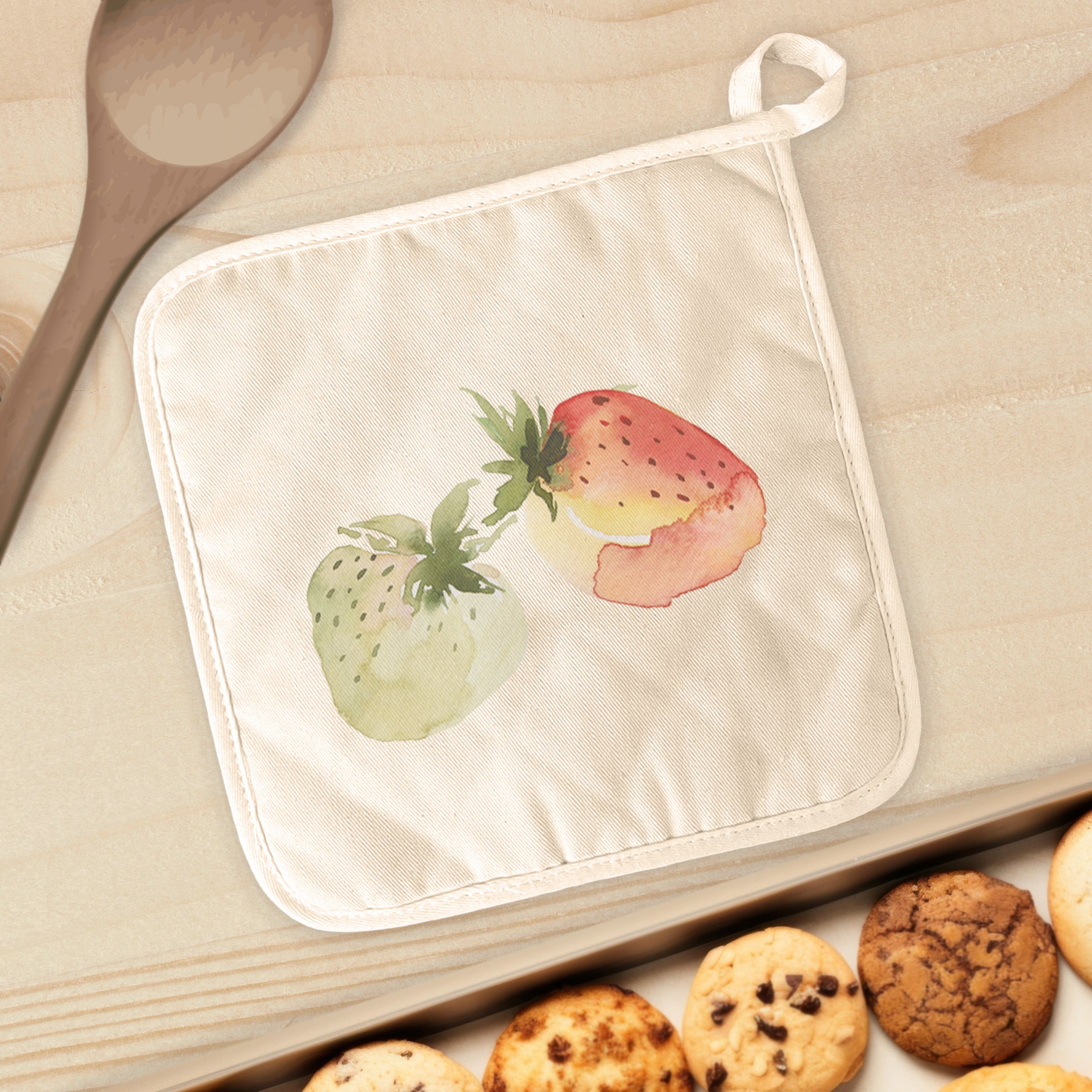 A vibrant watercolor strawberry design on a cotton pot holder, showcasing its quilted terry cloth texture and convenient hanging loop.