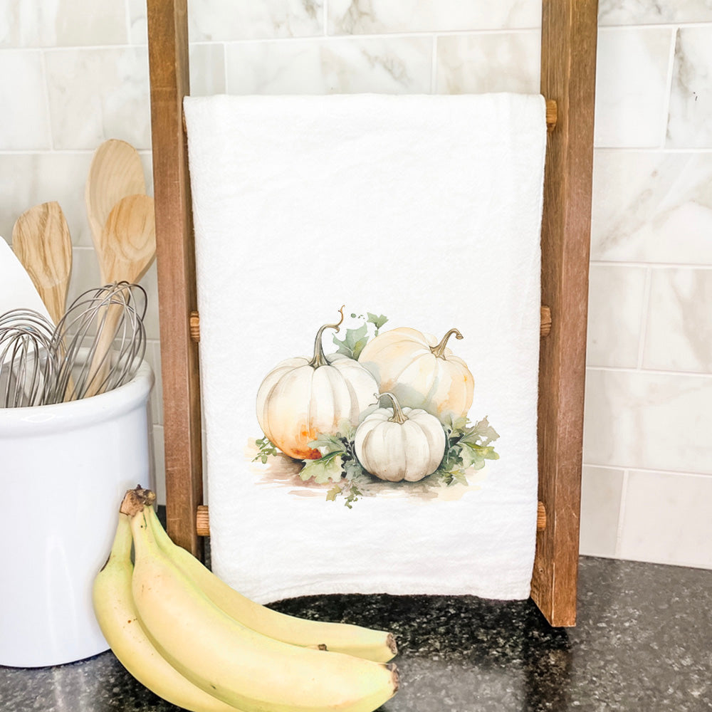 A beautifully designed White Pumpkins Cotton Tea Towel featuring vibrant colors and hemmed edges, perfect for kitchen use.