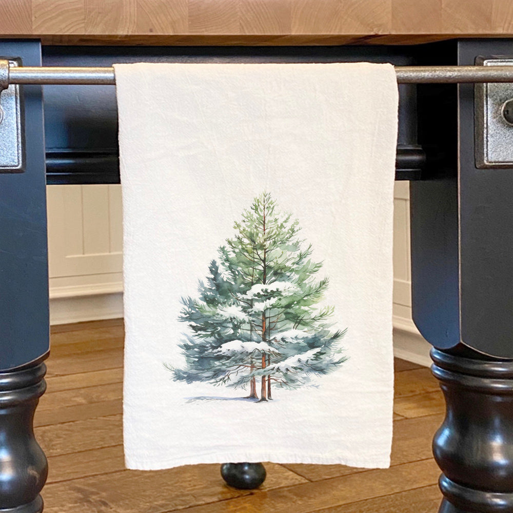 A vibrant cotton tea towel featuring a winter pine tree design, perfect for festive kitchens.