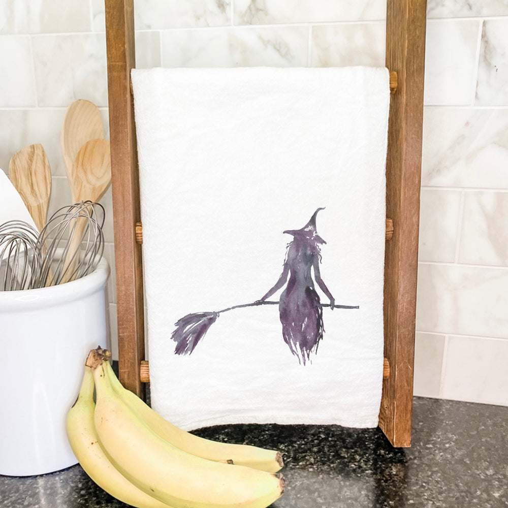 A cotton tea towel featuring a whimsical witch silhouette design, perfect for kitchen use.