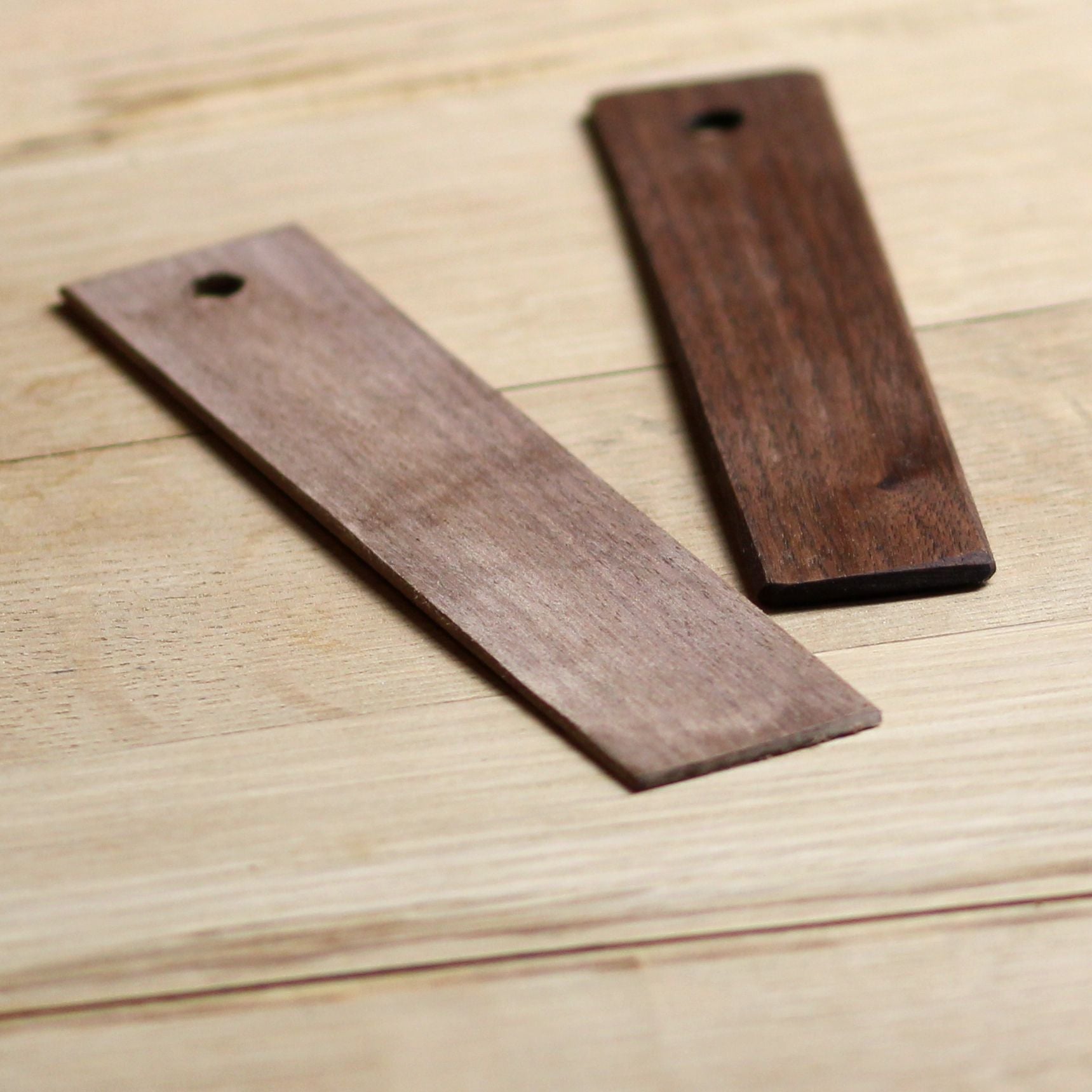 A set of 10 eco-friendly wooden bookmarks in various finishes, showcasing their customizable engraving options.