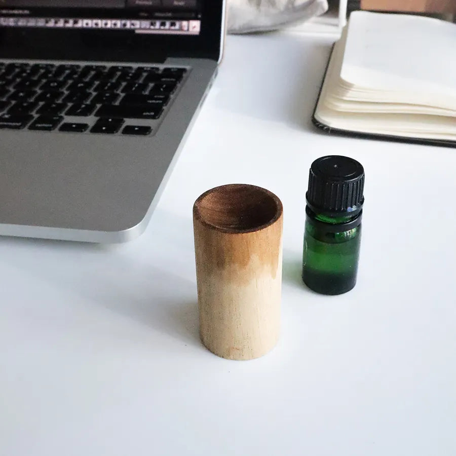 A beautifully crafted wooden essential oil diffuser, showcasing its natural wood grain and compact design, perfect for travel and aromatherapy.