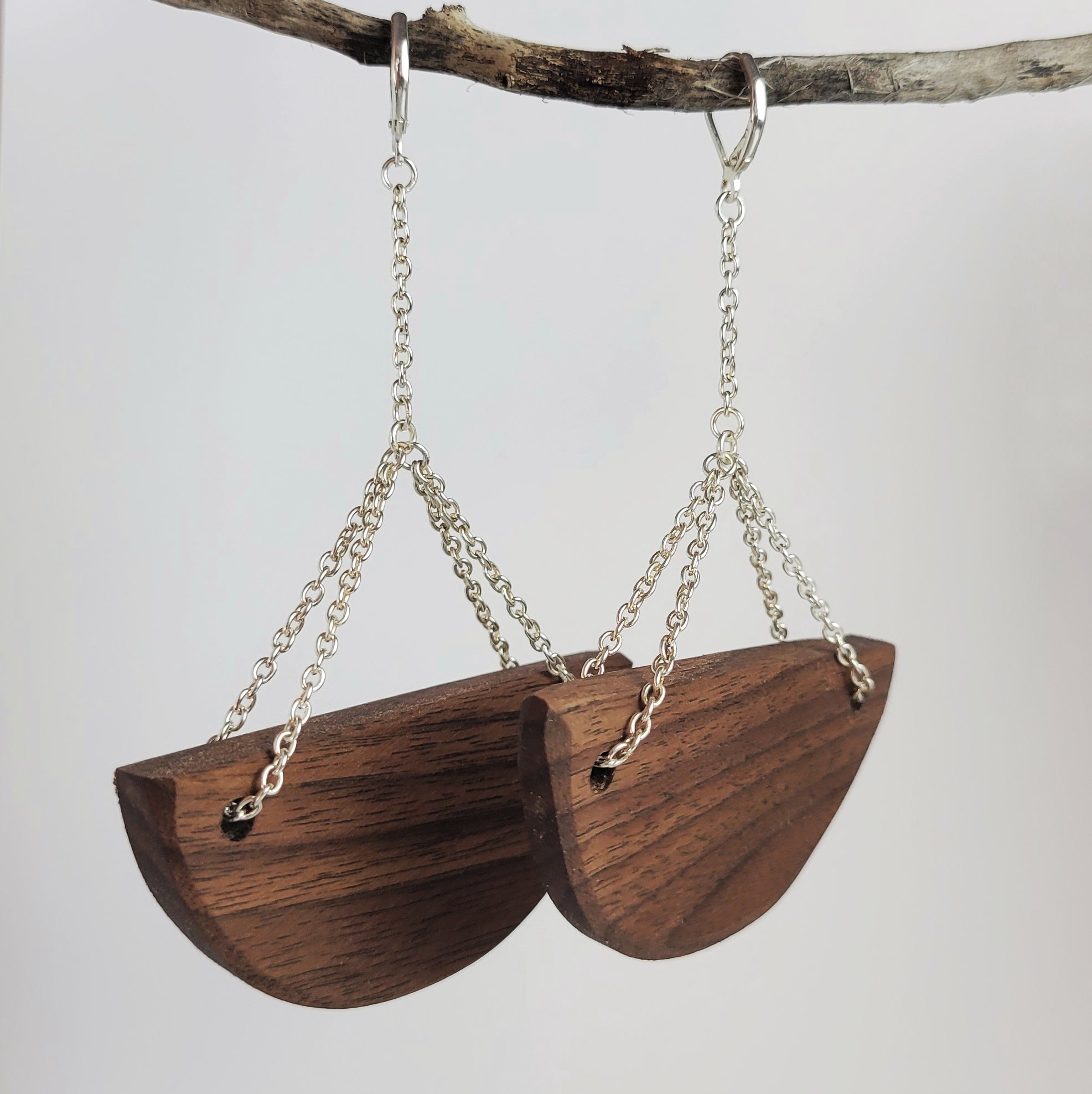 Handmade wooden half-moon earrings with silver plated attachments, showcasing cherry and walnut wood options.