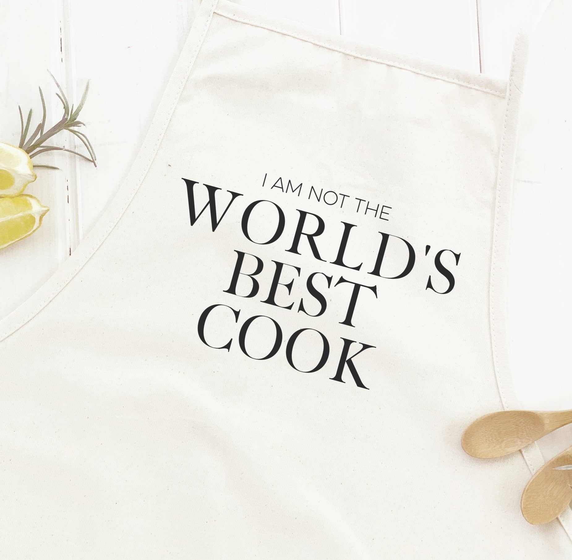 Stylish women's apron with 'World's Best Cook (NOT)' print, featuring natural twill ties and a divided front pocket.