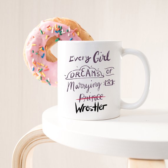 A humorous coffee mug featuring the phrase 'Every Girl Dreams Of Marrying A Wrestler', crafted from high-quality ceramic.