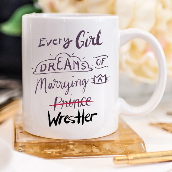 A humorous coffee mug featuring the phrase 'Every Girl Dreams Of Marrying A Wrestler', crafted from high-quality ceramic.