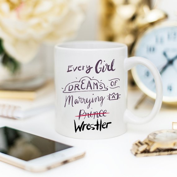 A humorous coffee mug featuring the phrase 'Every Girl Dreams Of Marrying A Wrestler', crafted from high-quality ceramic.