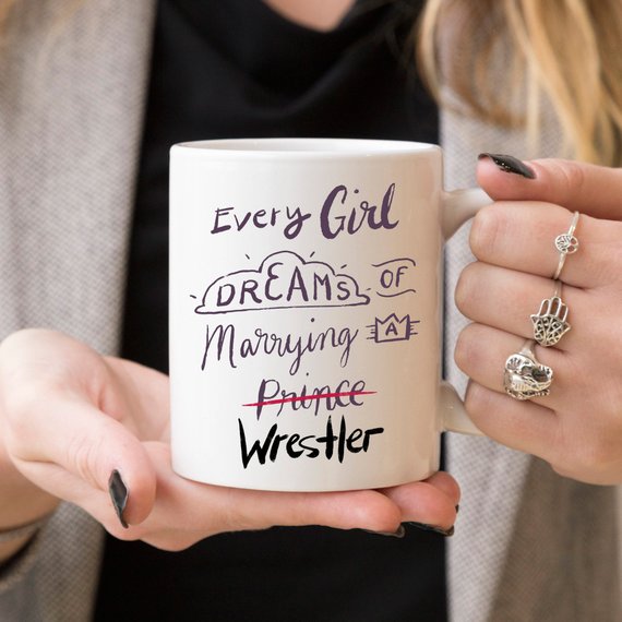 A humorous coffee mug featuring the phrase 'Every Girl Dreams Of Marrying A Wrestler', crafted from high-quality ceramic.