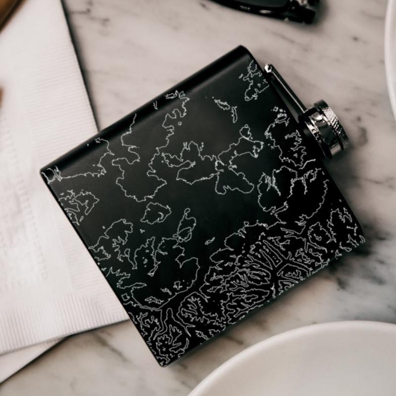 Matte black hip flask featuring a custom engraved map of Yellowstone National Park, complete with coordinates.