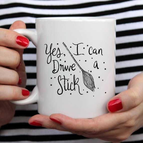 A humorous coffee mug featuring the phrase 'Yes I Can Drive A Stick', perfect for Halloween and coffee lovers.