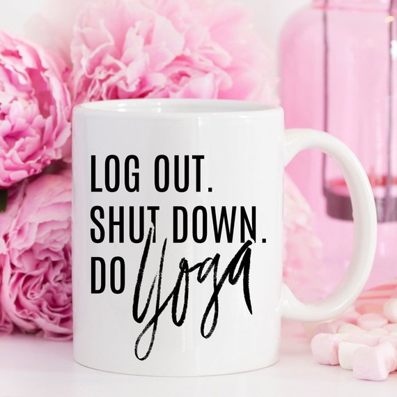 A humorous Yoga Mug with the phrase 'Log Out, Shut Down. Do Yoga' printed on it, showcasing its ceramic design and 11 oz capacity.