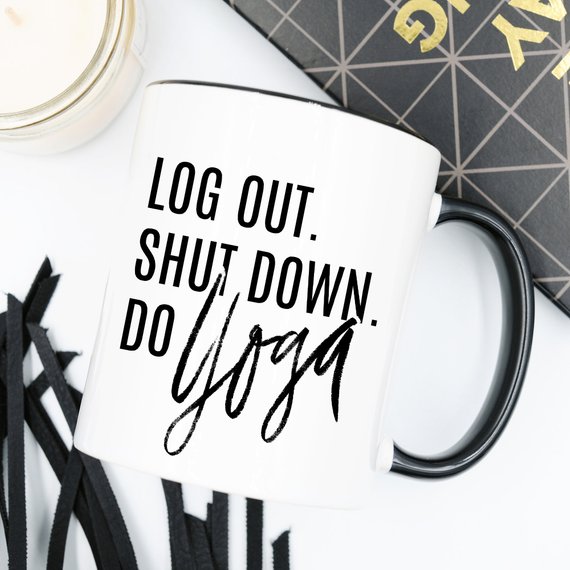 A humorous Yoga Mug with the phrase 'Log Out, Shut Down. Do Yoga' printed on it, showcasing its ceramic design and 11 oz capacity.