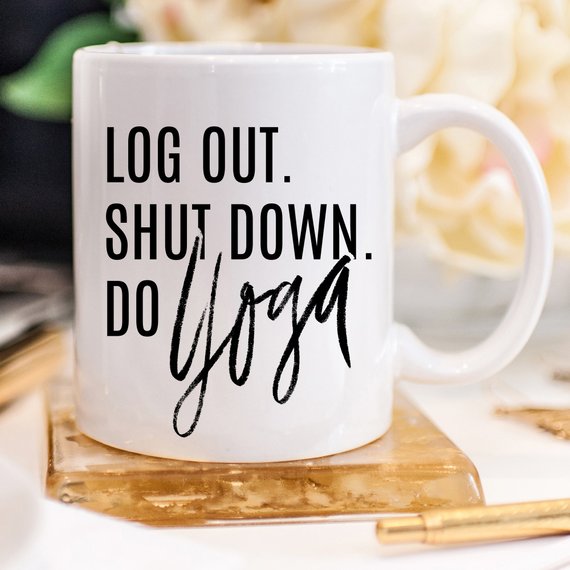 A humorous Yoga Mug with the phrase 'Log Out, Shut Down. Do Yoga' printed on it, showcasing its ceramic design and 11 oz capacity.