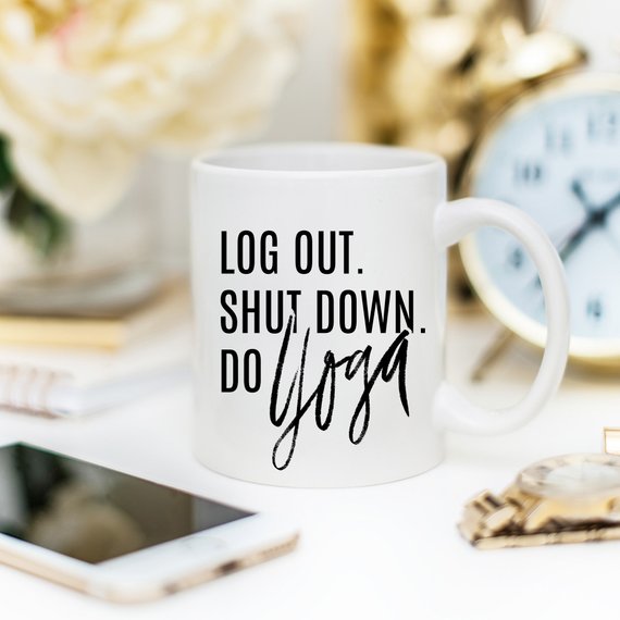 A humorous Yoga Mug with the phrase 'Log Out, Shut Down. Do Yoga' printed on it, showcasing its ceramic design and 11 oz capacity.