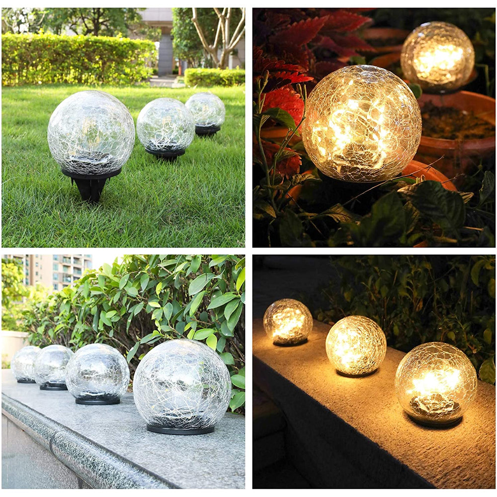 Two solar lights with cracked glass ball design illuminating a garden path at night, showcasing warm LED light patterns.